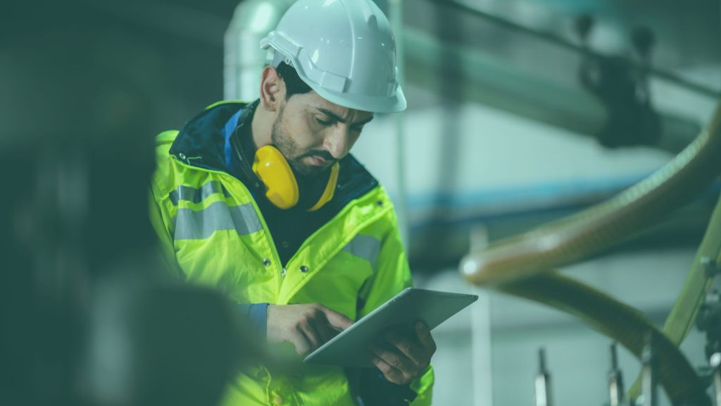 Man with hardhat reading clipboard