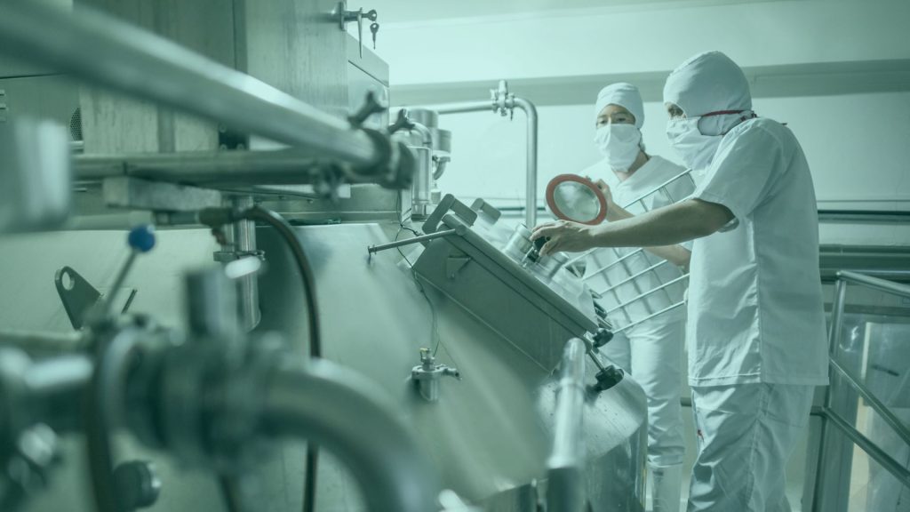 Two scientists in full PPE checking machine