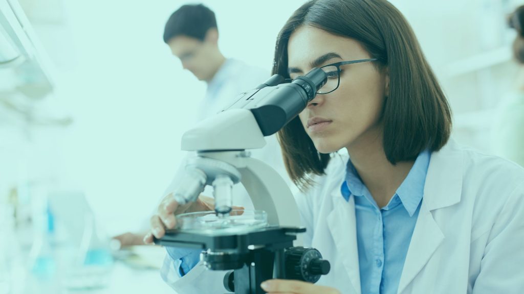 Female scientist looking in microscope